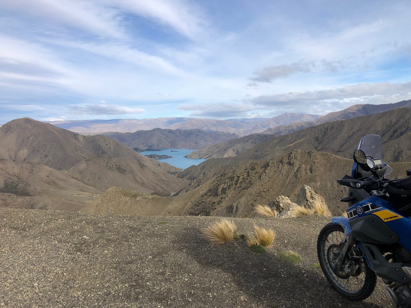 High country road signpost beside a loaded adventure bike