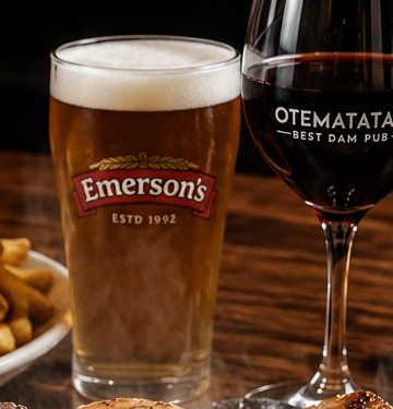 A pint of Emerson's beer beside a glass of red wine on the bar